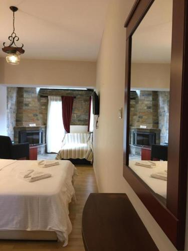 a hotel room with two beds and a mirror at Tasia Mountain Hotel in Chania