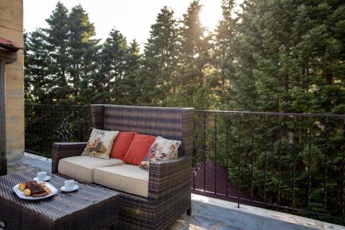 a wicker chair sitting on a balcony with a table at Tasia Mountain Hotel in Chania