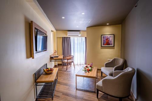 a living room with two chairs and a table at Regenta Central Puri Odisha in Puri