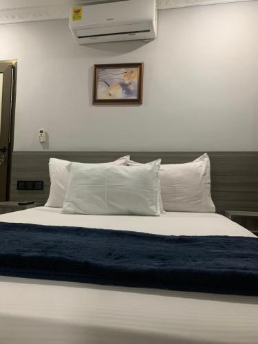 ein Bett mit weißen Kissen und einer blauen Decke in der Unterkunft Mnc Homes Akrowa house in Labadi
