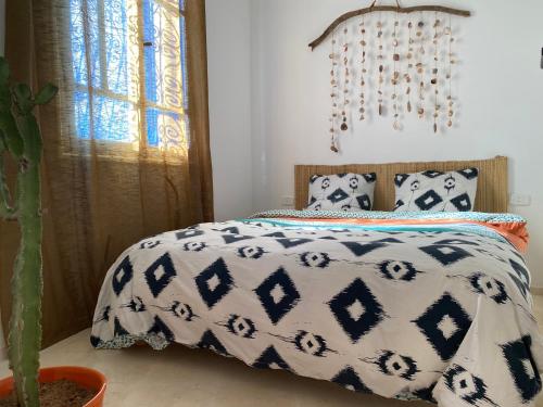 a bedroom with a bed with a black and white comforter at Cosy home in Sidi Bou Said in Sidi Bou Saïd