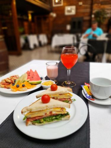 stolik z dwoma talerzami kanapek i drinka w obiekcie Bellavista express w mieście Santiago