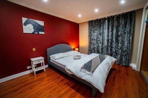 ein Schlafzimmer mit einem Bett und einer roten Wand in der Unterkunft Park Lorne in London