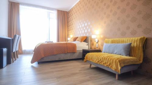 a bedroom with a bed and a couch and a window at Premium City Centre Bedrooms in Prešov