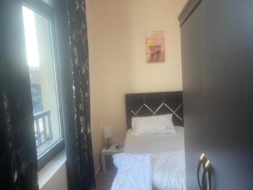Four Stars Hostel في دبي: غرفة نوم صغيرة بها سرير ونافذة