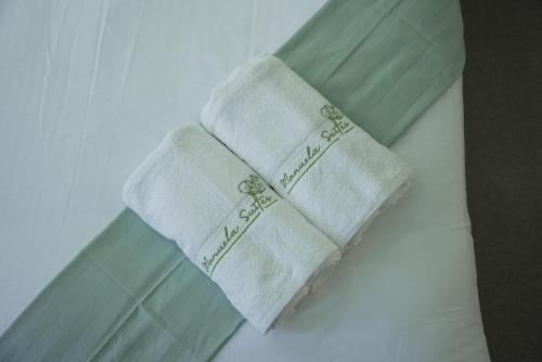 a pair of towels sitting on top of a bed at OYO 1063 Manuela's Suites in Puerto Princesa City