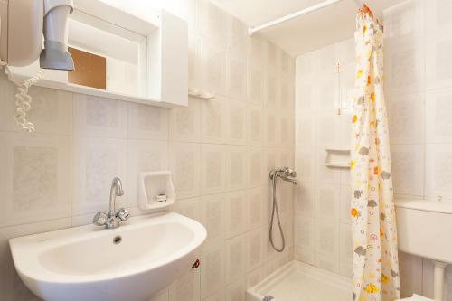 a bathroom with a sink and a shower curtain at MON REPOS in Panormos Skopelos