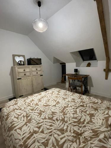 a bedroom with a bed and a dresser and a television at La chambre de la tanière in Muzillac
