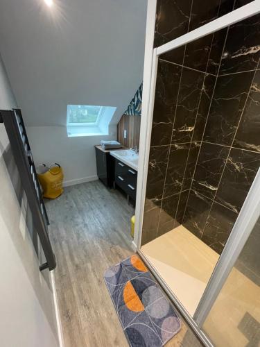 a bathroom with a glass shower door in a room at La chambre de la tanière in Muzillac