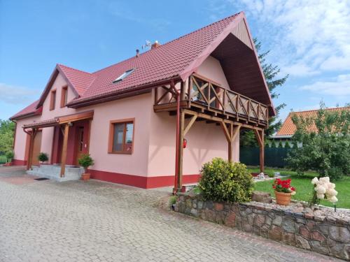 a small pink house with a red roof at Apartament u Rybaka in Sędki
