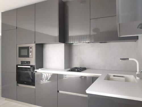 uma cozinha com armários de aço inoxidável e um micro-ondas em Central, brand new apart with parking em Blagoevgrad