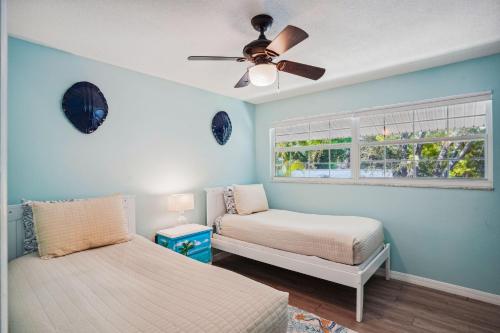 Cette chambre comprend 2 lits dans une chambre dotée d'un ventilateur de plafond et d'une fenêtre. dans l'établissement Relax On The Rocks, à Clearwater Beach