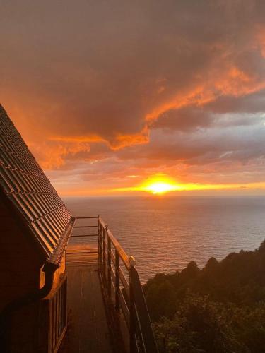 a view of a sunset from a deck with the ocean at Panorama Sarpi 029 in Batumi
