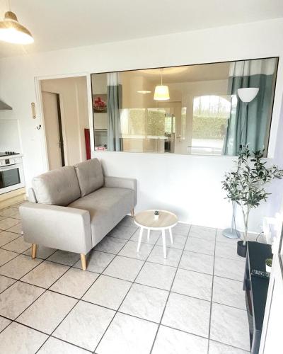 uma sala de estar com um sofá e uma mesa em Le cocon em Eugénie-les-Bains
