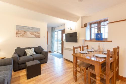 sala de estar con mesa y sofá en Elidir Cottage en Llanfairpwllgwyngyll