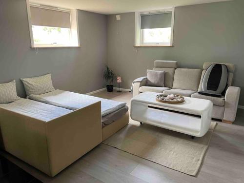 a living room with a couch and a table at Cozy ground floor apartment in nature, by driving 300 metres of gravel road on top of the hill in Lunde