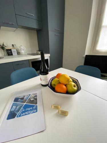 都靈的住宿－La casa di Beatrice e Francesca，一瓶葡萄酒和一碗水果放在桌子上