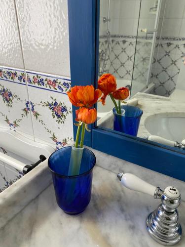 um vaso azul com flores sentado no lavatório da casa de banho em La casa di Beatrice e Francesca em Turim