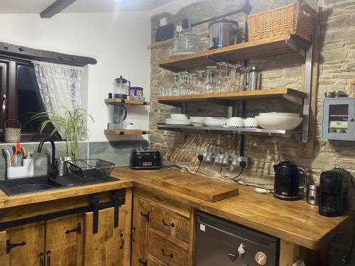 a kitchen with wooden cabinets and a counter top at Horseshoe Cottage in Looe