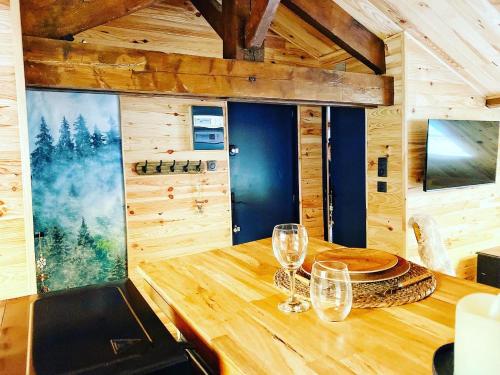 a table in a cabin with wine glasses on it at Le Chalet in Verdun-sur-Meuse