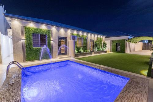 - une piscine dans l'arrière-cour d'une maison la nuit dans l'établissement شاليهات الجوري, à Al Harazat