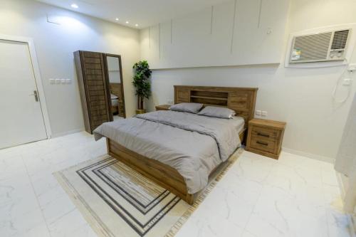 um quarto com uma cama grande e um espelho em شاليهات الجوري em Al Harazat