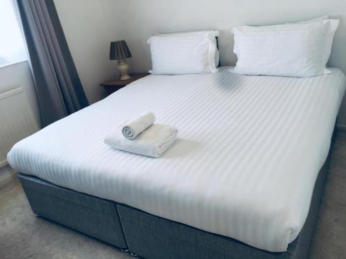 uma cama branca com uma toalha em cima em Jessjoe em Bournemouth
