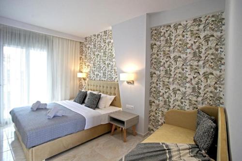 a bedroom with a bed and a chair in a room at EL MARE ROOMS in Pefkochori