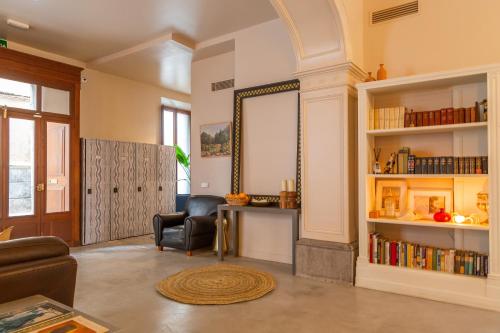 a living room with a chair and a mirror at SólleRooms in Sóller