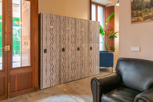 a large wooden door in a living room with a couch at SólleRooms in Sóller