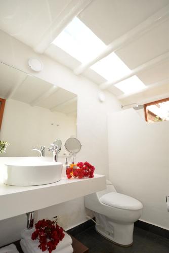 a white bathroom with a sink and a toilet at Hotel Casa Terra in Villa de Leyva