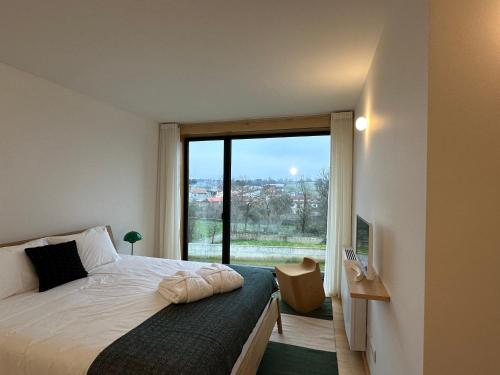 a bedroom with a bed and a large window at PÉ AZUL - Turismo em Espaço Rural - Parque Natural de Montesinho in Bragança