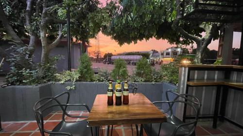 una mesa de madera con cuatro botellas de vino. en Hotel BJ Curumani, en Curumaní