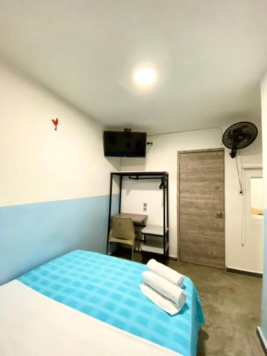 a bedroom with a bed and a table and a door at Hotel Anauco in Bucaramanga