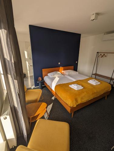 a hotel room with two beds and a chair at 1851 Bar - Hotel - Cinema in Wijk bij Duurstede
