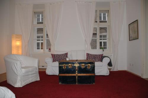 uma sala de estar com duas cadeiras brancas e uma bagageira em Beautiful Central Flat Top-17 em Viena
