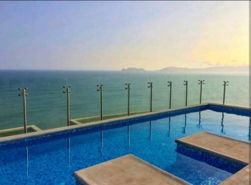 una piscina con el océano en el fondo en Panoramic Aparment San Miguel en Lima