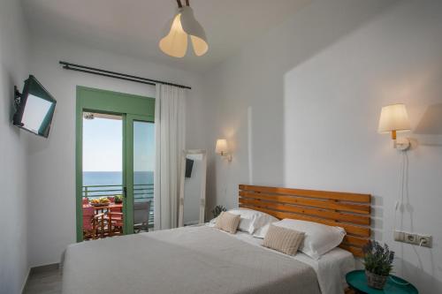 a bedroom with a bed with a view of the ocean at EGLI LUXURY APARTMENTS in Archangelos