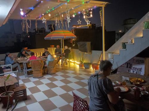 eine Gruppe von Personen, die in einem Restaurant an Tischen sitzen in der Unterkunft Taj Street Hostel in Agra