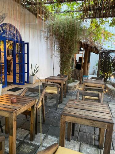 a group of wooden tables sitting outside of a building at Seconds Hostel - Colombo in Colombo