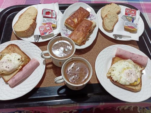 uma bandeja com pratos de alimentos para o pequeno-almoço e chávenas de café em Nikos Rooms em Loutra Edipsou