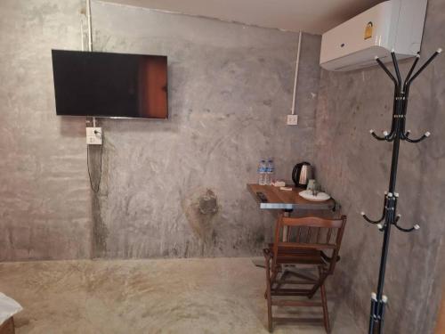 a room with a table and a television on a wall at Samui Camping Farm in Laem Sor