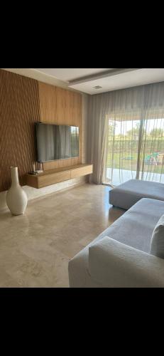 a bedroom with a bed and a flat screen tv at Golf prestigia marrakech rez de jardin in Marrakesh