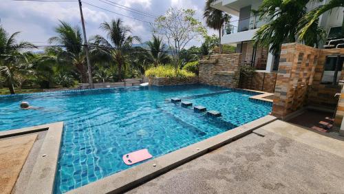 a swimming pool in front of a house at Plus condominium 2 kathu in Ban Thung Thong