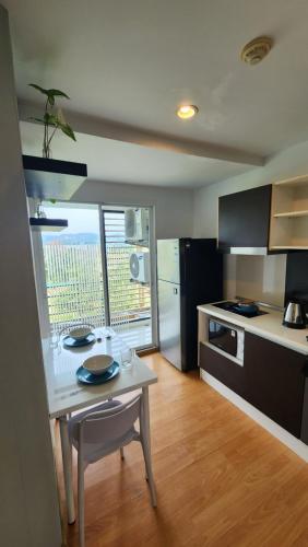 a kitchen with a table and a counter top at Plus condominium 2 kathu in Ban Thung Thong