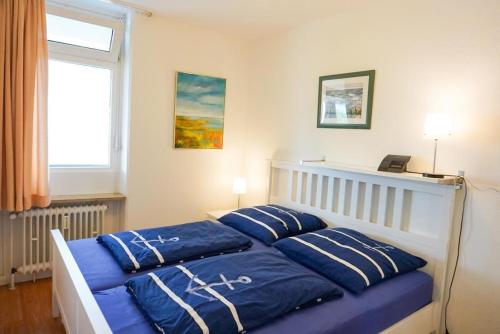 シャルボイツにあるFerienwohnung-212-im-Berliner-Hofのベッドルーム1室(青い枕のベッド1台、窓付)