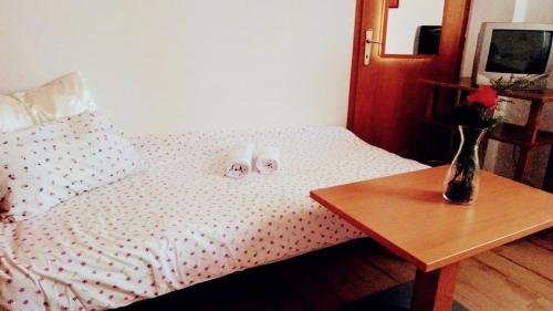 a bed with two stuffed animals on it with a table at Hotel Markovi Kuli TD in Prilep