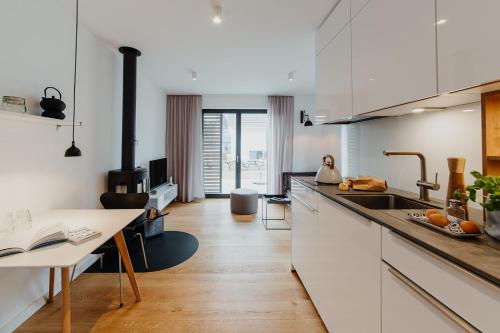 a kitchen with white cabinets and a sink and a table at SandKorn 1 und 2 in Pruchten