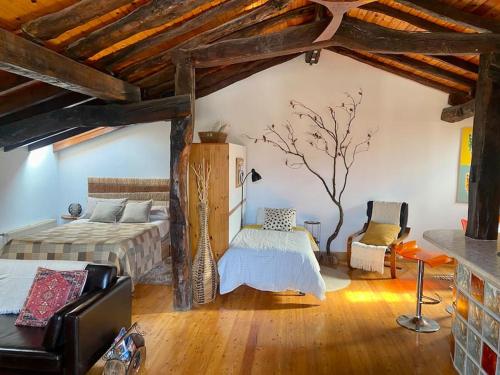 1 dormitorio con 1 cama y un árbol en la pared en BILBO Near ático rural con terraza, en Basauri