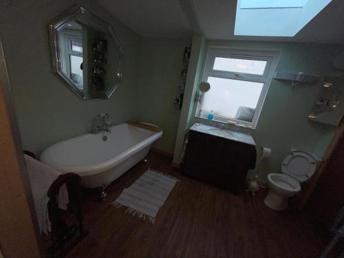 łazienka z wanną, toaletą i oknem w obiekcie Lovely double room in very good area w Edynburgu